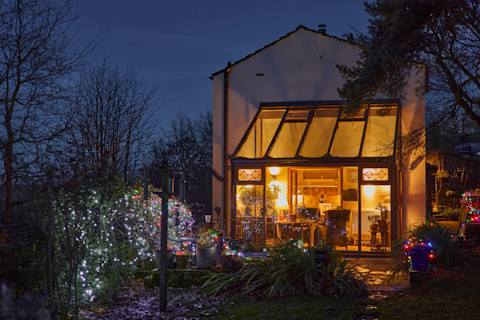 Warm conservatory with Christmas decorative lights at Yorkshire smallholding cottage