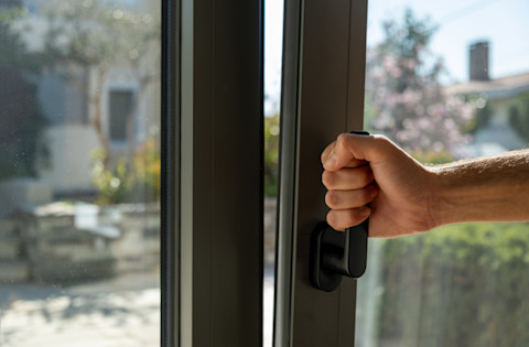 Someone opening a tilt & turn window.