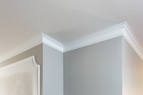 This image shows a close up of wall coving. The coving and wall are painted white.
