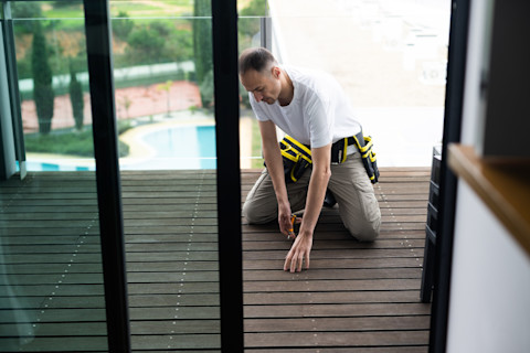 A man is constructing a porch extension