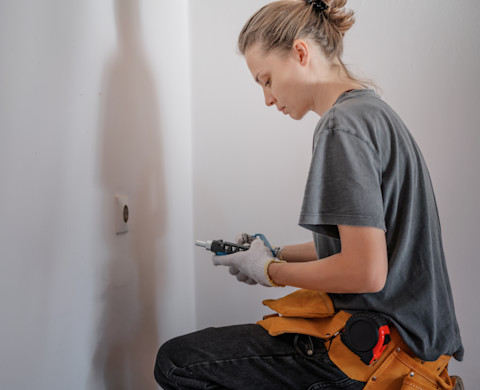 A tradesperson is installing plug sockets in a new house.