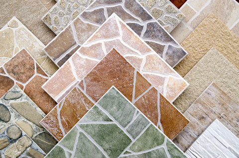 This image shows a close-up view of colourful ceramic tile samples displayed in a shop, showcasing a variety of textures and patterns.