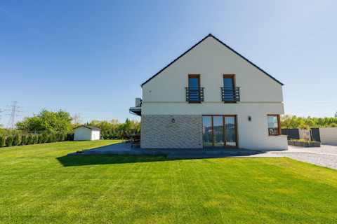 This image shows a new build home with a neat and minimalist garden with short green grass.