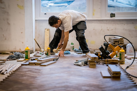 A floor fitter fixing a resin flooring.