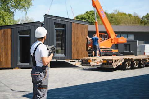 A man is transporting a garden room.
