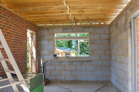 The frame of a new garage being built with bricks and carpentry.