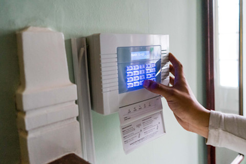Someone is creating a setting on a burglar alarm.