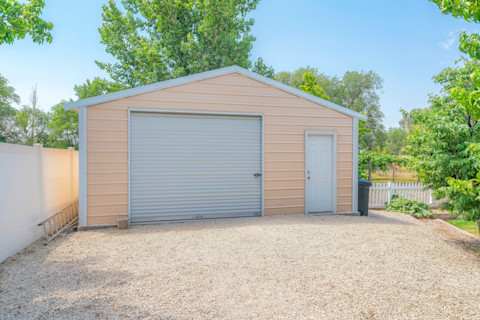 Detached gable garage exterior with steel walls and roll-up door with door latch lock