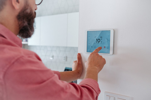 Heating engineer checking a thermostat.