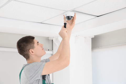A man is installing a new CCTV system.