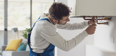 A tradesperson is working on a broken boiler.