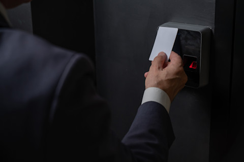 A man entering a house with a card- a keyless entry.
